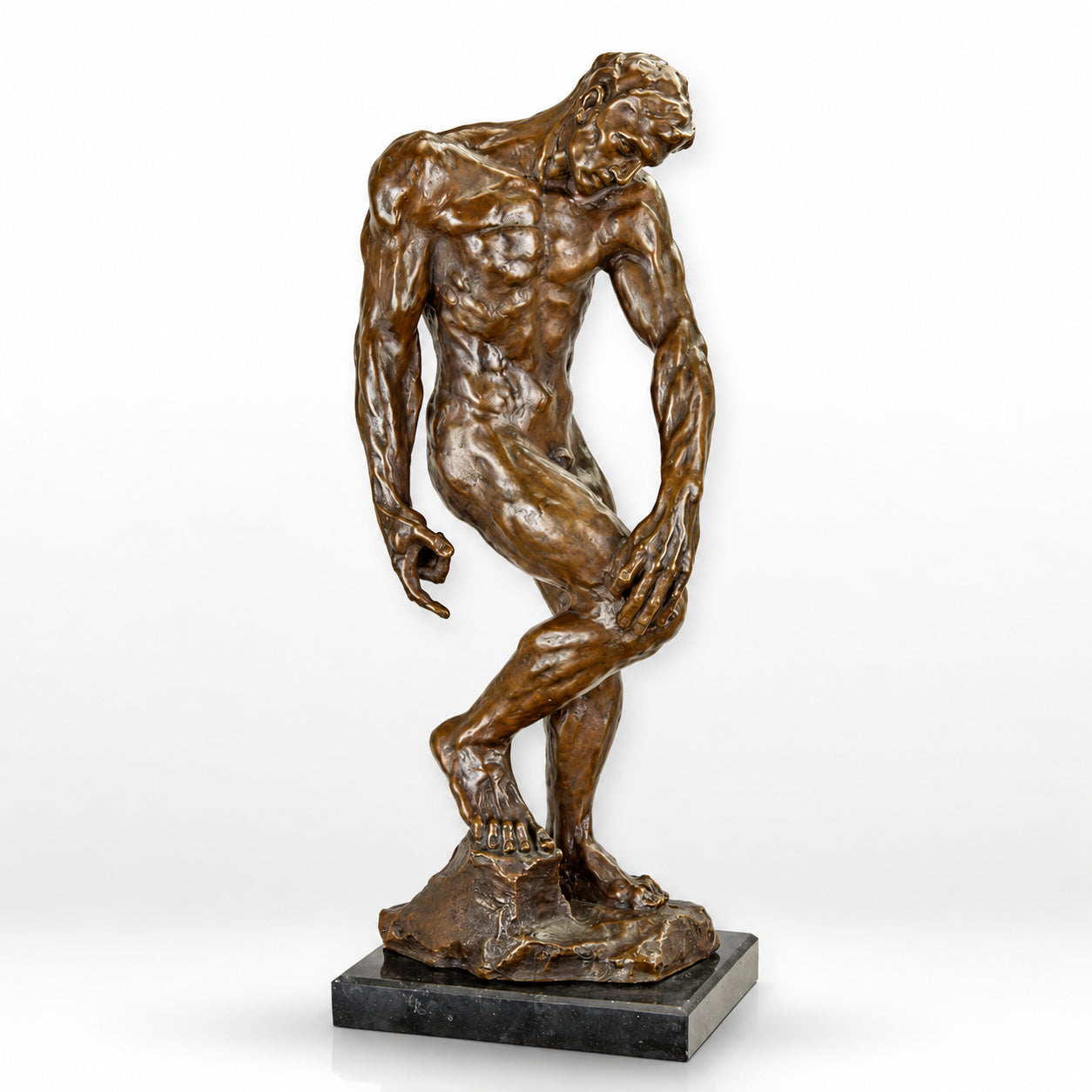 Handcrafted bronze sculpture of a contemplative nude male figure standing in an expressive pose on a black marble base.