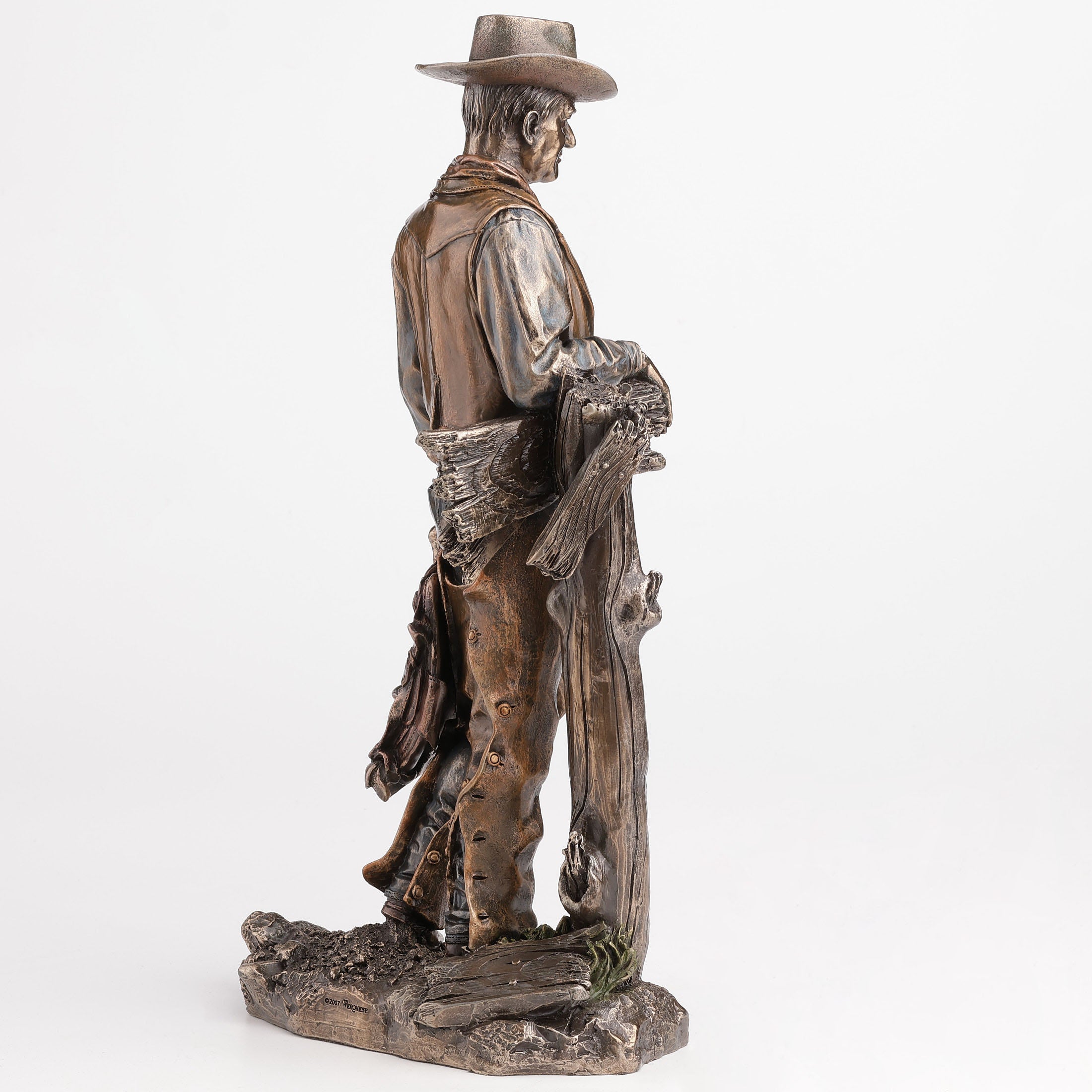 Cowboy Holding Saddle Leaning Against Fence Pole