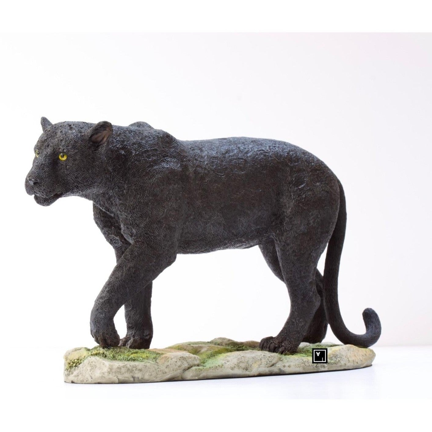 Realistic black panther sculpture with textured fur standing on a natural style base