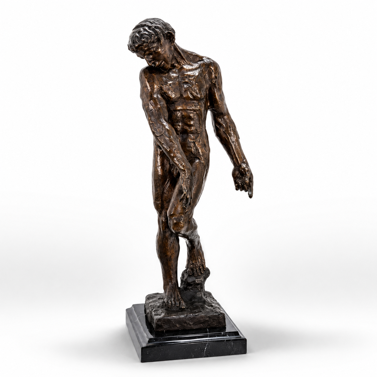 Handcrafted bronze contemplative male figure sculpture standing on a polished black marble base with a downward gaze and textured finish.