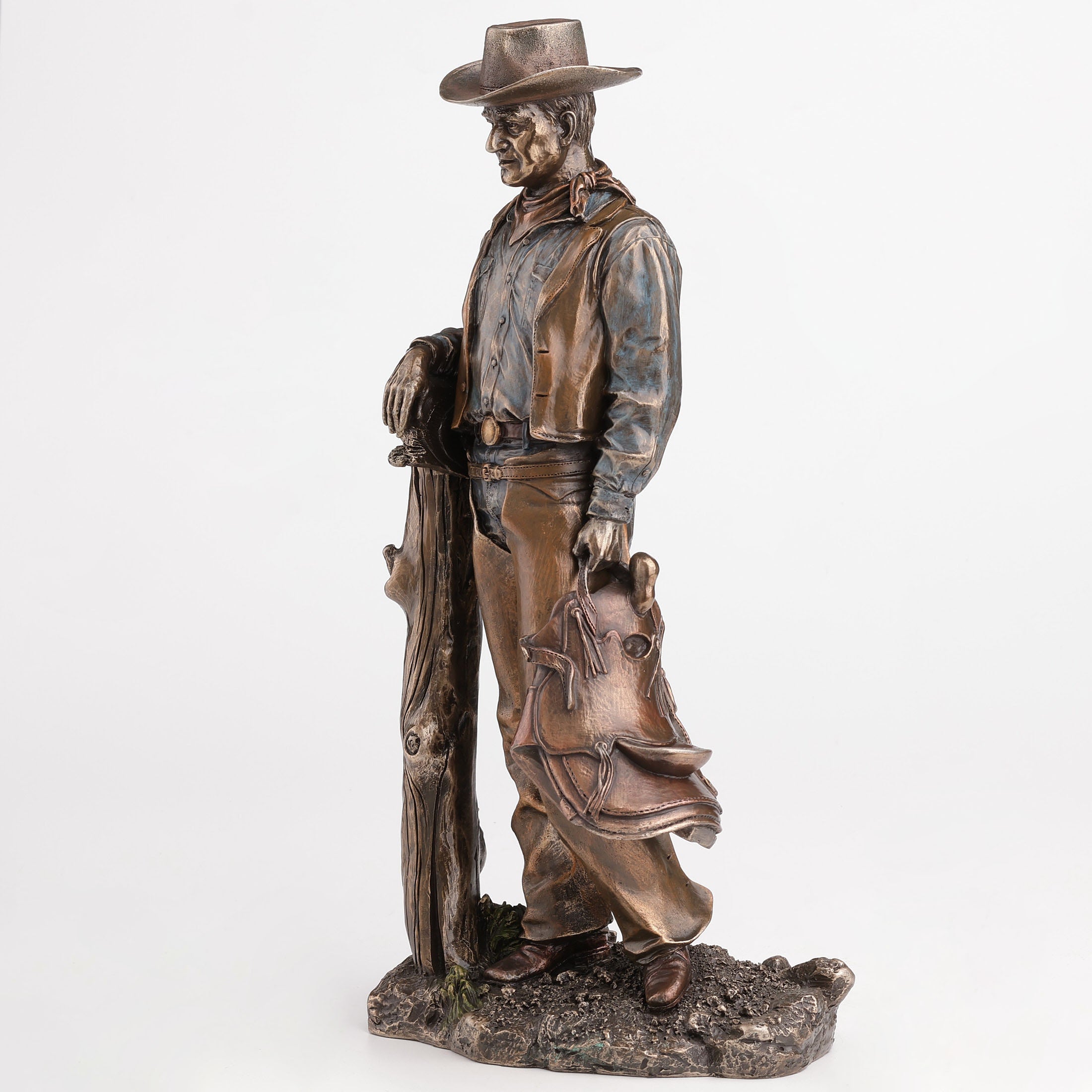 Cowboy Holding Saddle Leaning Against Fence Pole