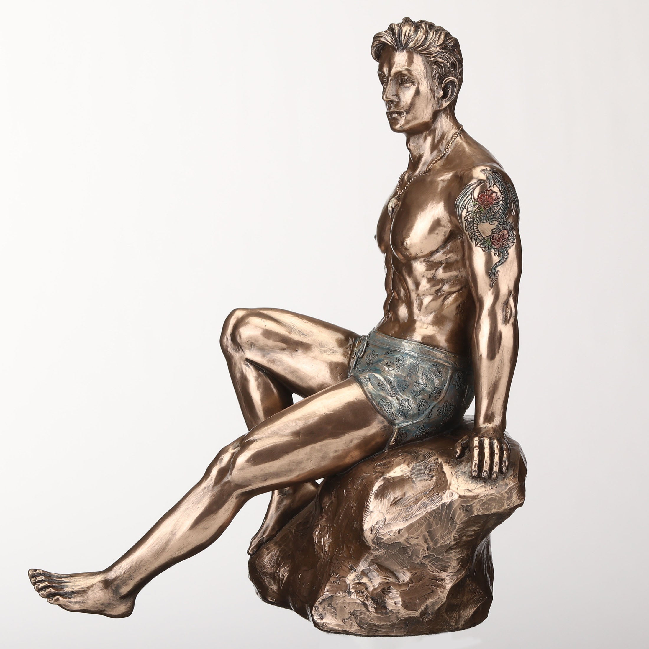 Tattooed Male Sitting On Rock Beach Pinup