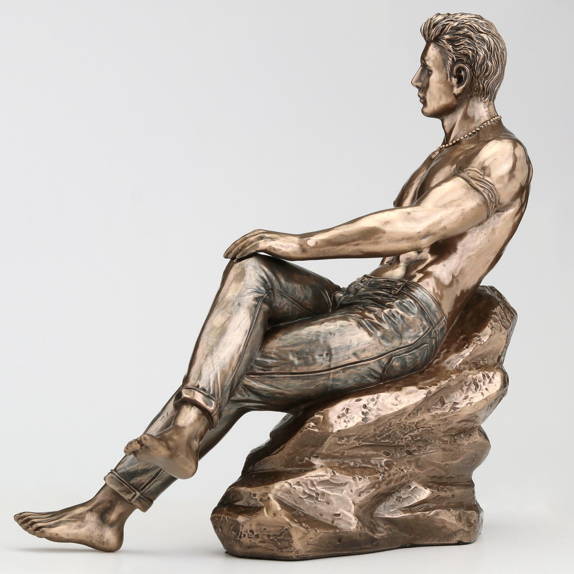 Tattooed Male In Jeans Pin Up Crossed Legs Lean On Rock