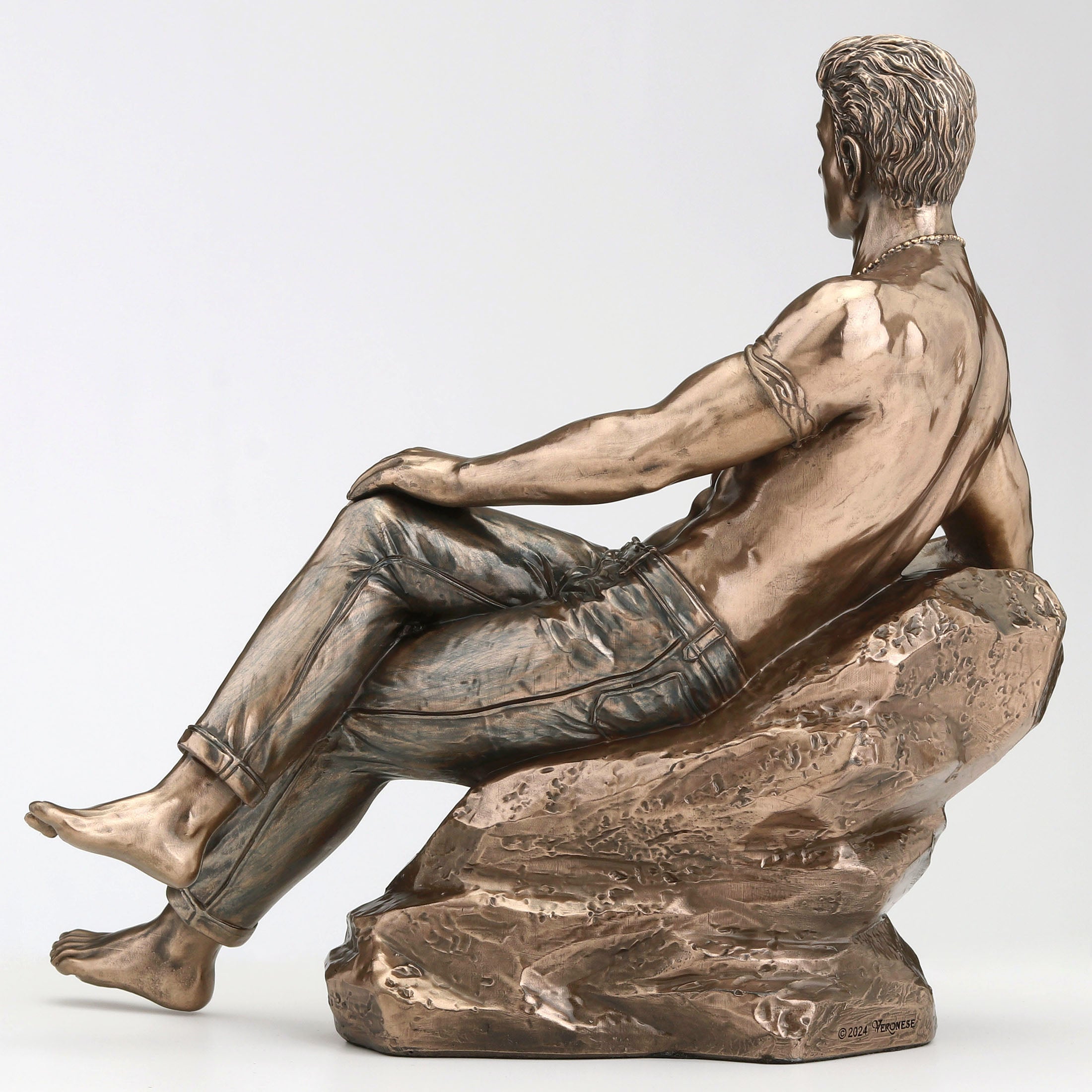 Tattooed Male In Jeans Pin Up Crossed Legs Lean On Rock